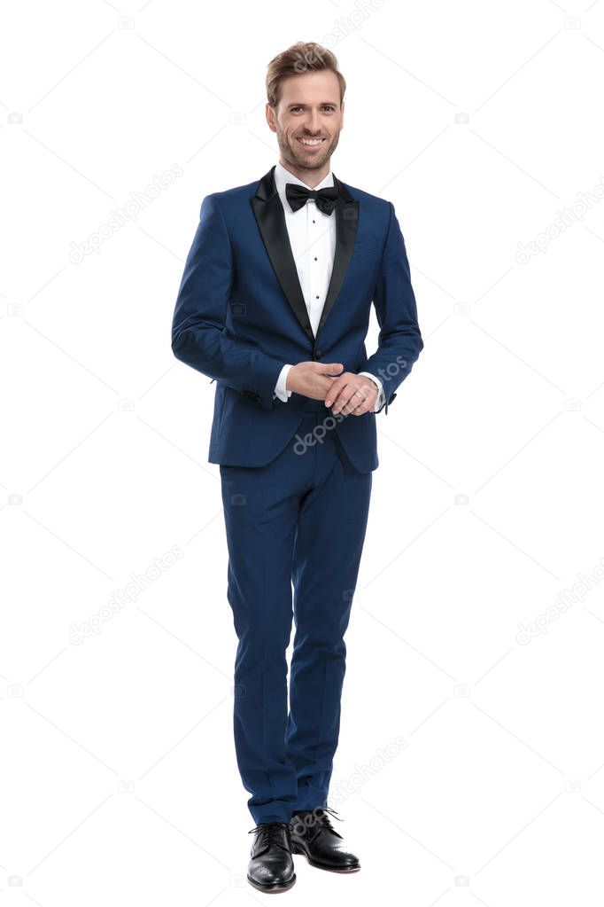 sexy smiling man in blue suit holding his hands together