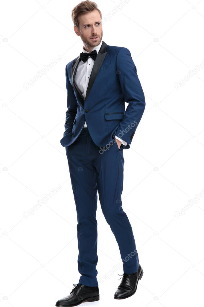 worried man in blue suit walking with hands in pockets