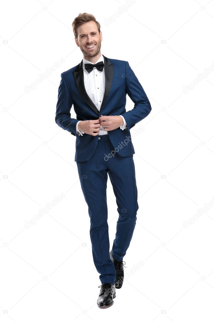 laughing man in blue tuxedo is buttoning his lounge jacket