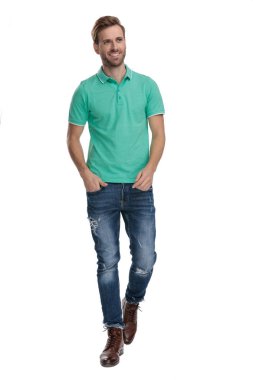 Genç adam ellerini cebine sokup başka tarafa bakıyor.