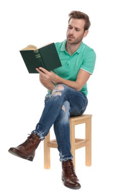 yeşil polo gömlek bir roman okuma oturan çekici adam