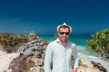 Tulum harabelerini ziyaret eden gülümseyen genç turist