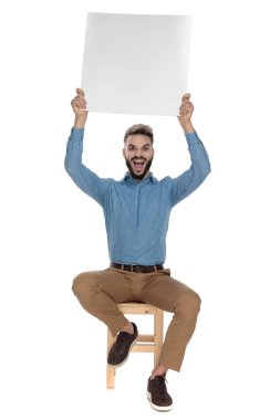 oturan öğrenci havada boş bir reklam panosu tutar