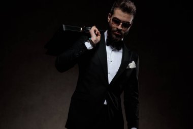 smokin ve güneş gözlüğü dramatik adam shoul üzerinde evrak çantası tutar