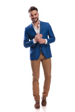 Takım elbiseli genç adam, el ele tutuşup duruyor.