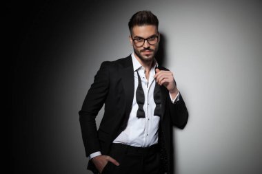 siyah smokin yakışıklı adam cebinde el tutan