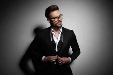 siyah smokin onun takım elbise düğmeleme yakışıklı genç adam