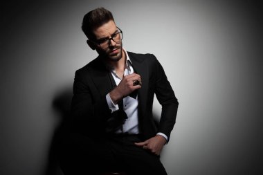 siyah smokin li çekici adam sandalyede oturuyor