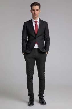 siyah takım elbiseli adam ceplerinde elleri ile ayakta