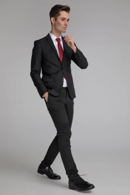 cebinde el ile yürüyen model adam yan görünümü