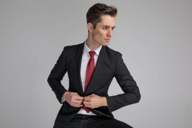 ciddi bir iş adamı bakarken onun lounge ceket düğmeleme