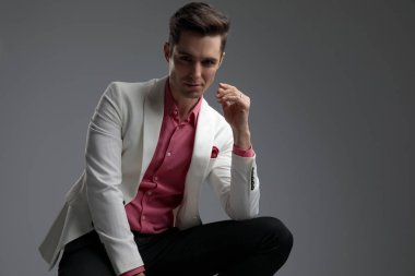 bacağına dirsek dayanayarak takım elbise ciddi adam oturmuş