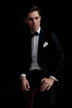 zarif ciddi adam sandalyede oturan ve uzağa bakıyor