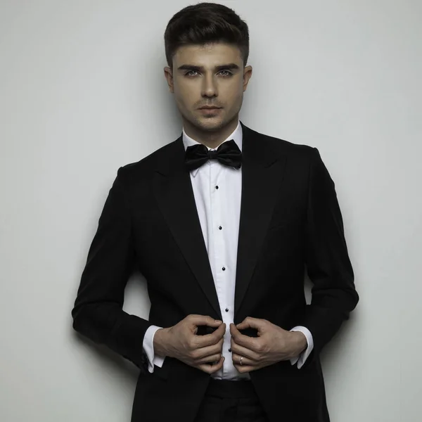 Sexy Geschäftsmann im schwarzen Smoking knöpft seinen Anzug auf — Stockfoto
