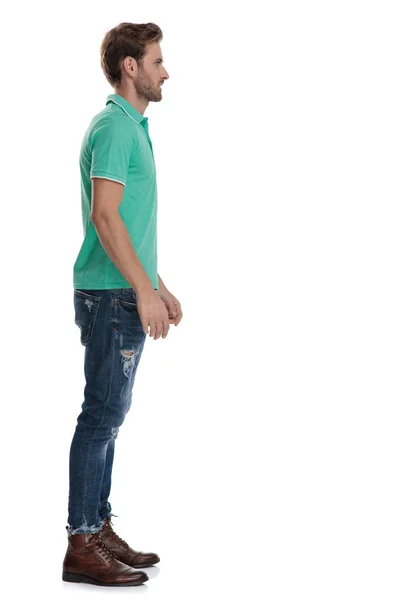 Vista lateral del hombre en polo verde esperando en línea — Foto de Stock