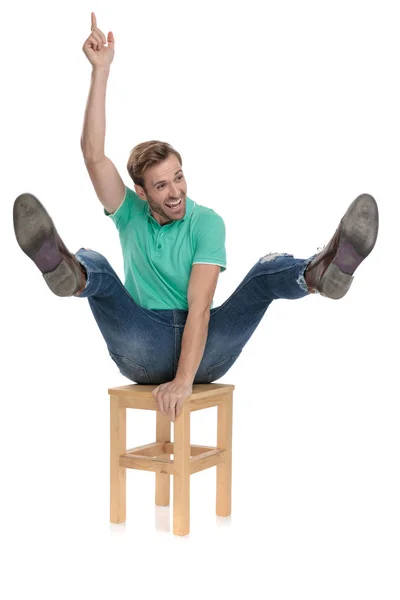 Attractive man riding chair like at rodeo being a cowboy — Stock Photo, Image