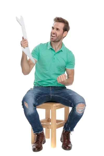 Guy screaming with number one sign in hand while sitting — Stock Photo, Image