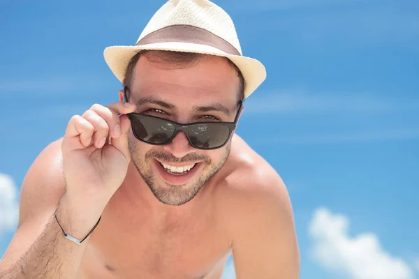 Smiling young topless man takes off his sunglasses — Stock Photo, Image