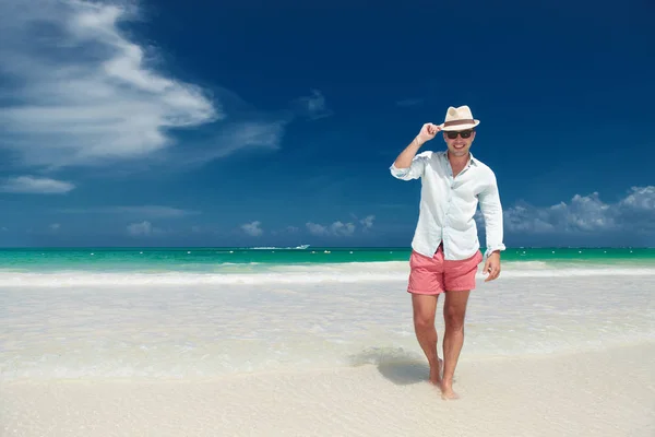 Glücklicher Mann lässt grüßen, während er am Strand spaziert — Stockfoto