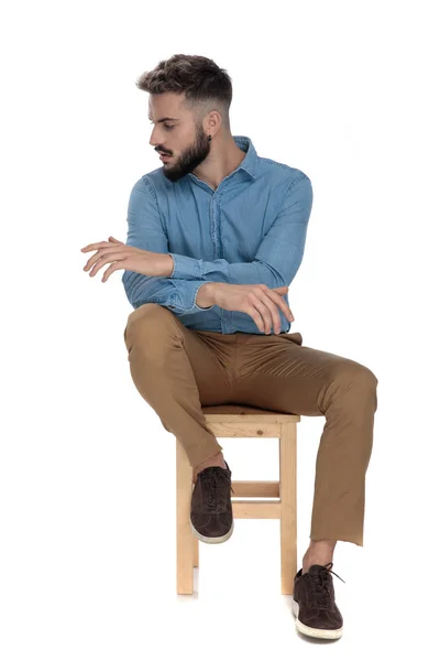 Sitzender Student schaut mit gekreuzten Händen weg — Stockfoto