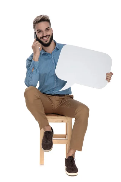 Hombre relajado sentado en la silla y hablando por teléfono —  Fotos de Stock