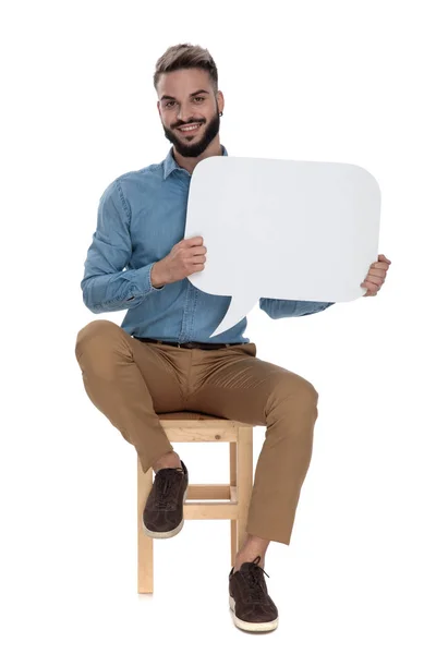 Χαλαρός άνθρωπος κάθεται με μια κενή φούσκα μήνυμα στα χέρια — Φωτογραφία Αρχείου