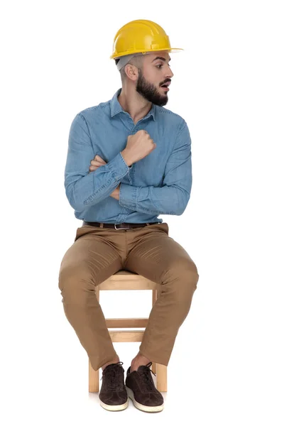 Bello uomo minacciando con pugno mentre seduto con le braccia incrociate — Foto Stock