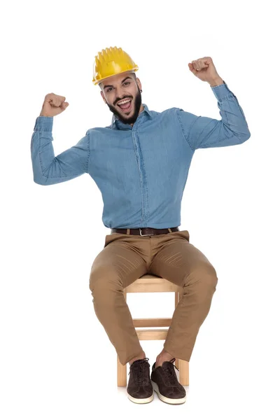 Ingeniero de construcción sentado con las manos en el aire mostrando música — Foto de Stock