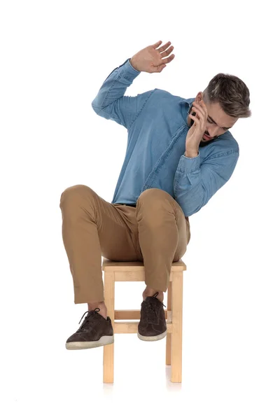 Sentado asustado hombre en azul jeans camisa defendiendo con las manos —  Fotos de Stock