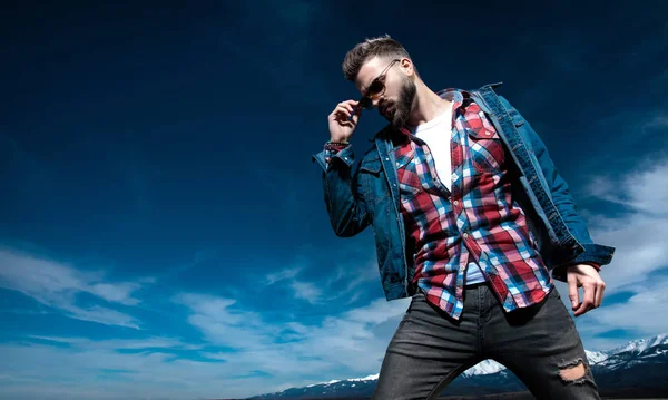 Serio hombre casual mirar hacia abajo mientras posando al aire libre — Foto de Stock