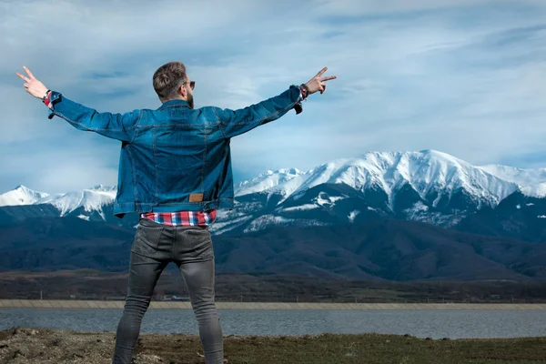 Ung man i denim kläder firar frihet utomhus — Stockfoto