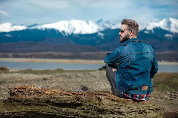 Sentado hombre casual mirando a un lado y admirando la vista — Foto de Stock