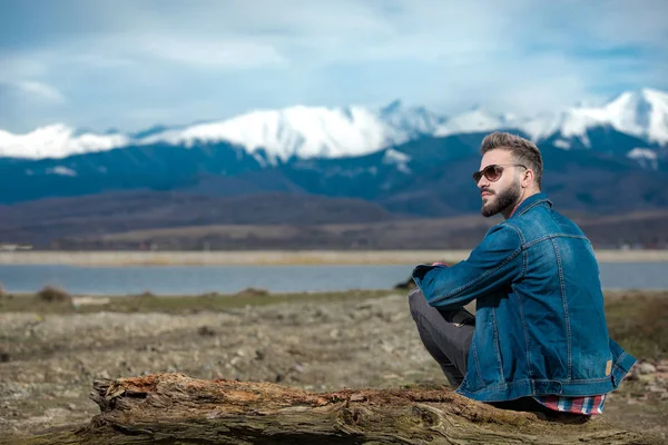 Man droomt weg terwijl zittend op een oude log outdoor — Stockfoto