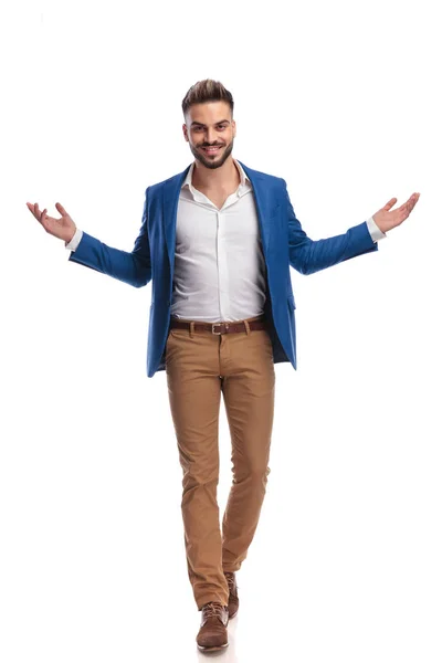 Casual man in suit greeting with arms opened while walking — Stock Photo, Image