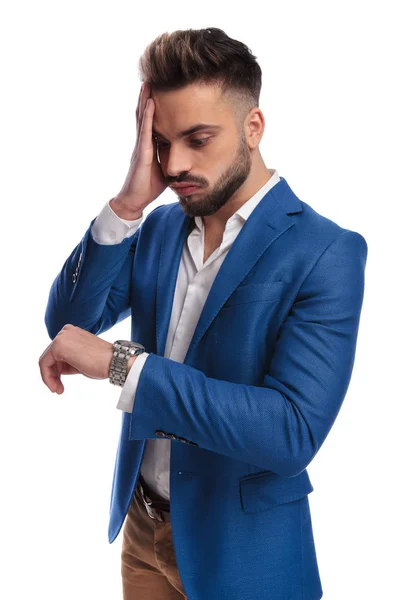 Hombre de moda mirando reloj que llega tarde con la mano en la cara —  Fotos de Stock