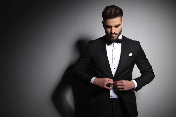 Caucasian man in black tuxedo buttoning his suit — Stock Photo, Image