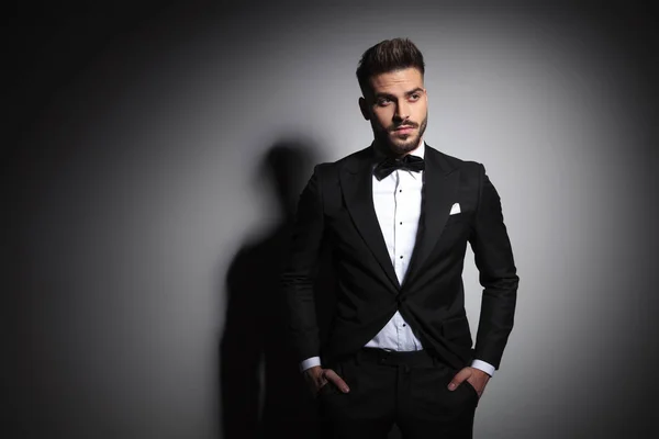 Elegant man in black tuxedo standing with hands in pockets — Stock Photo, Image