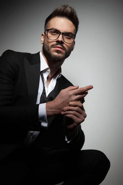 Handsome guy in black tuxedo rubbing hands — Stock Photo, Image