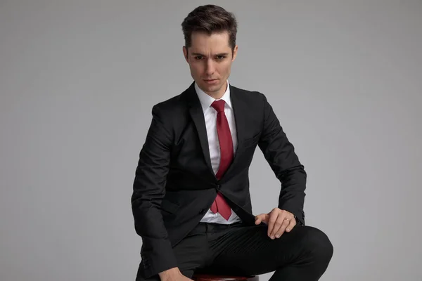 Serio ragazzo elegante seduto con le mani sulle gambe — Foto Stock