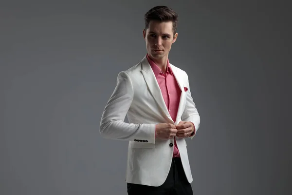 Yakışıklı adam uzağa bakarken onun salon ceketi düğmeleme — Stok fotoğraf