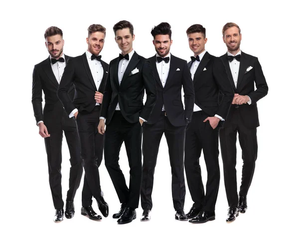 Groep van elegante jonge mannen in smokings samen staande — Stockfoto