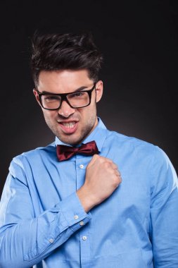 Kendinden emin genç adam yumruğu sıkılmış kameraya bakıyor