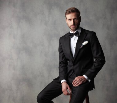 Otururken kameraya bakan kendine güvenen damat