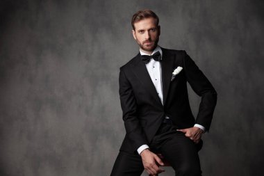 Ciddi görünümlü genç damat kameraya bakıyor