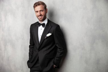 Pozitif genç adam gülümseyerek ve kameraya bakıyor