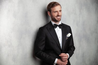 Neşeli damat kollarını sabitleme ve yan bakıyor