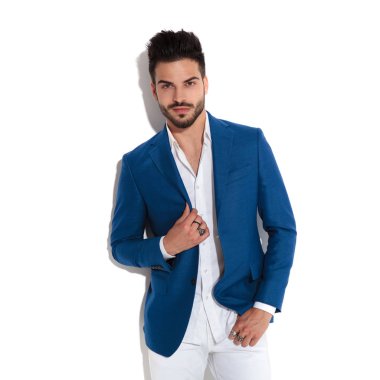 Mavi ceketini ayarlayan kendinden emin görünümlü adam