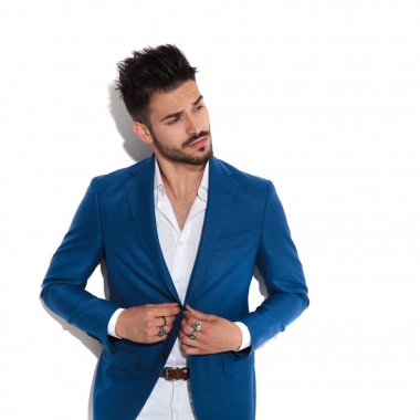 Şaşkın adam merakla ceketini ayarlıyor.