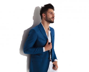 Şehvetli adam yan bakıyor ve ceketini ayarlama