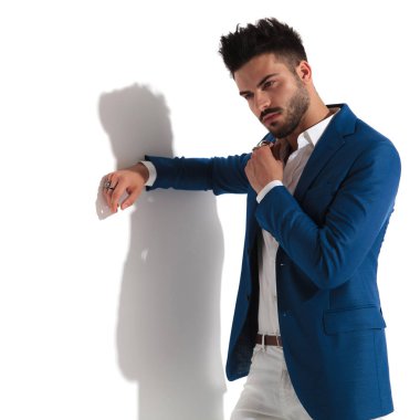 Şaşkın adam uzağa bakıyor ve tasmasını düzeltiyor. 